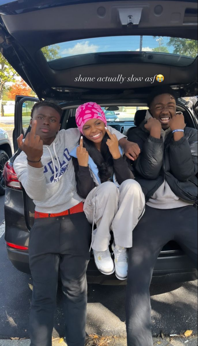 three people sitting in the trunk of a car