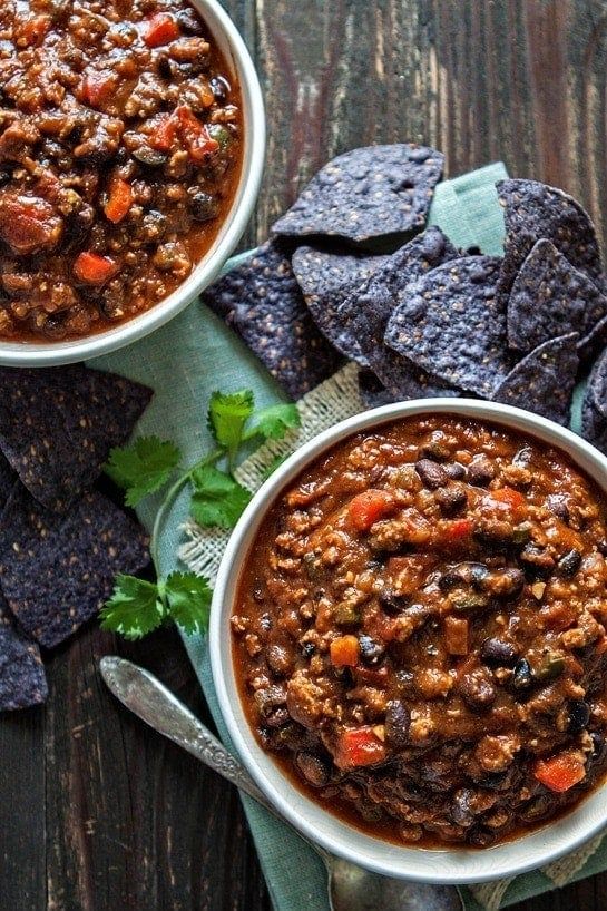 two bowls filled with chili and tortilla chips