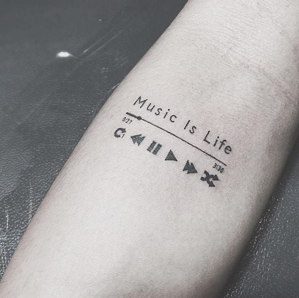 a person with a tattoo on their arm that says music is life and arrows are in black ink