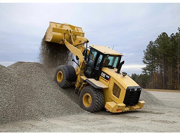 a bulldozer scoops gravel into a pile