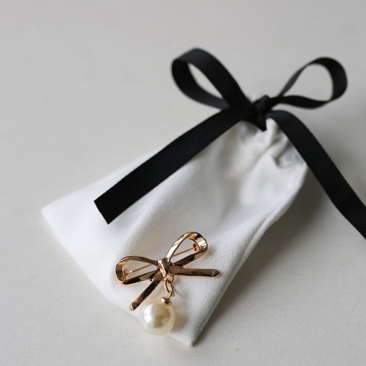 The Bow Brooch is here! Add this sweet classic pin to your any piece of clothing. The gold bow with a drop pearl is a great addition to any outfit. Wear this timeless brooch on a sweater, a blazer lapel, a dress or any top to give your outfit a little something extra. Approximately 1.25" x 1.125" Gift Bow Brooch, Chic White Formal Brooch, Chic Gold Brooches For Party, White Brooch With Decorative Bow For Gift, Gold Wedding Brooches Chic Style, Chic Gold Wedding Brooch, Gold Chic Wedding Brooches, Chic Gold Wedding Brooches, Gold Wedding Brooches In Chic Style