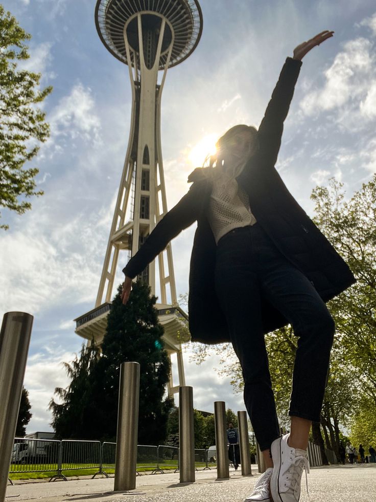 a woman is dancing in front of the space needle