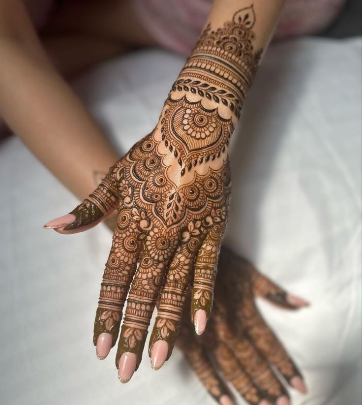 a woman's hand with henna tattoos on it