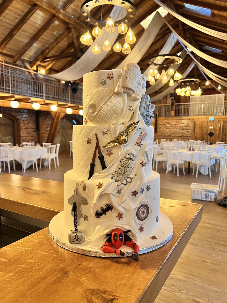 a wedding cake sitting on top of a wooden table in a room filled with tables and chairs