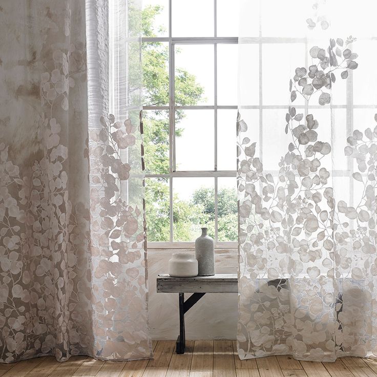 an open window with white sheer curtains in front of it and a wooden floor next to the window