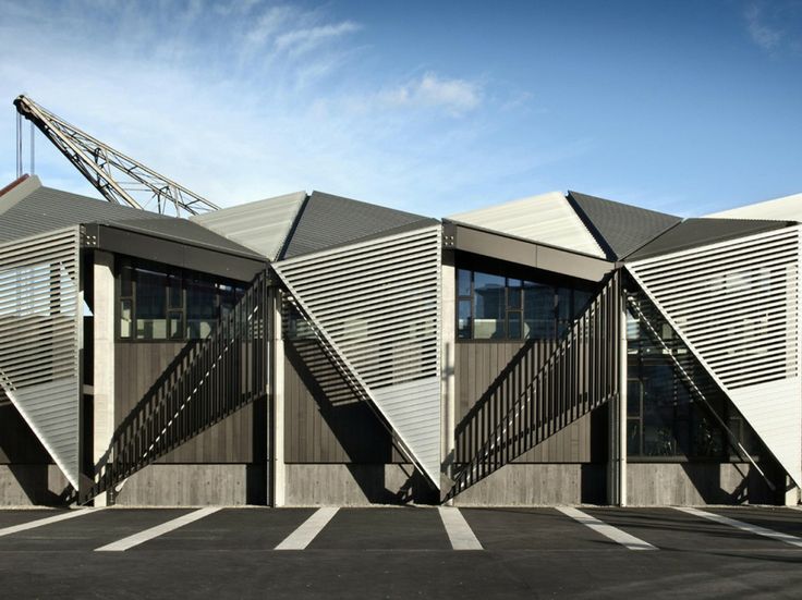 an architecturally designed building sits in the middle of a parking lot