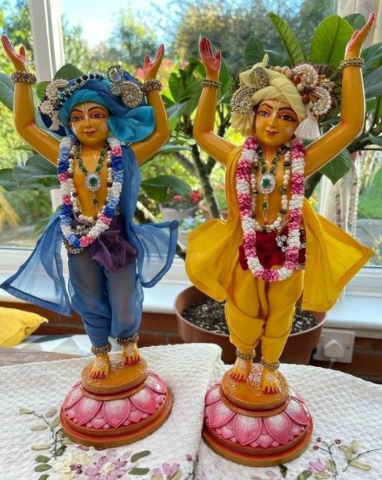 two figurines sitting on top of a table