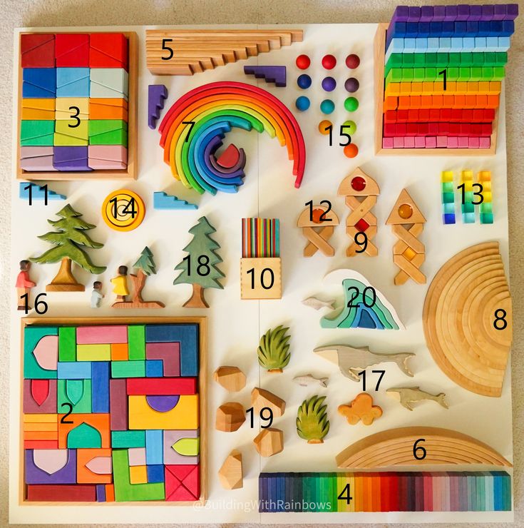 a variety of wooden toys are displayed on a white surface with colored pencils and crayons