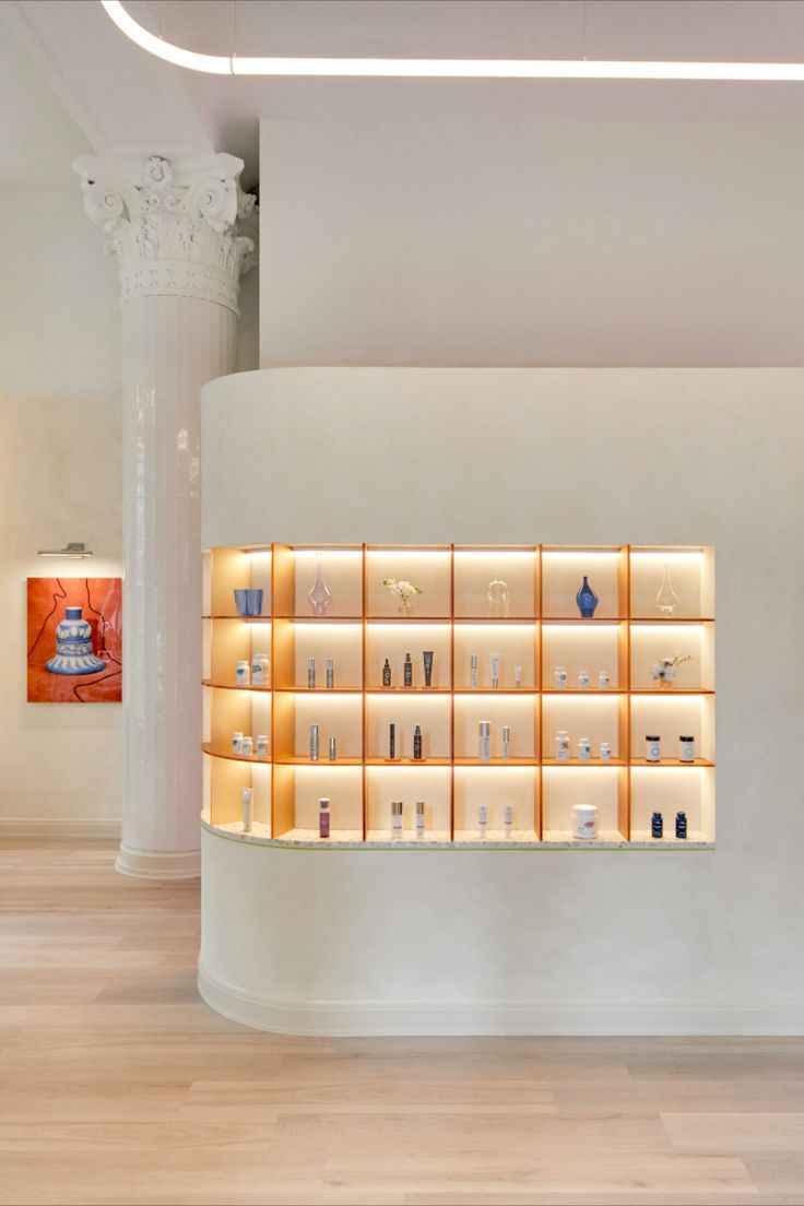 an empty room with several shelves filled with different types of items and lights on the wall