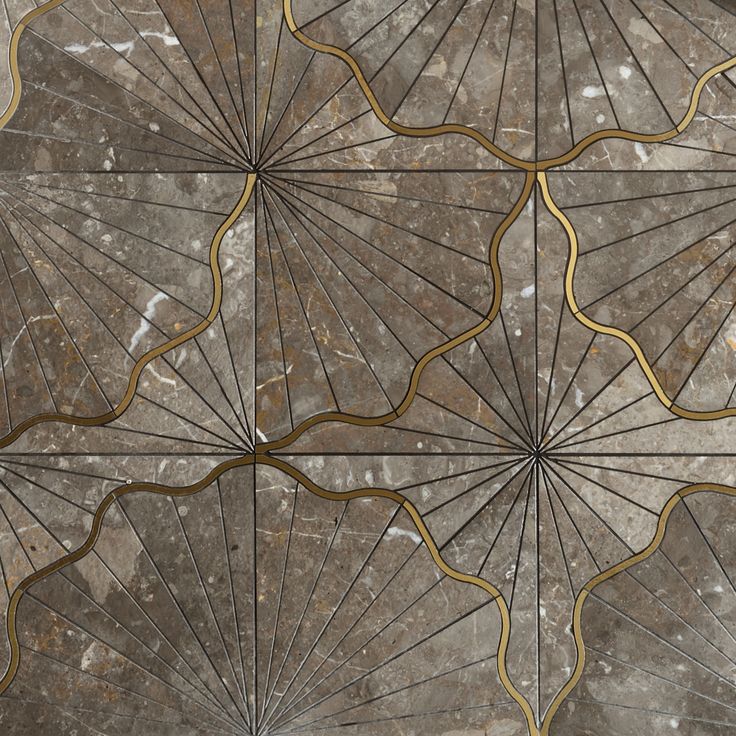 an intricately designed tile with gold lines and curves on the surface is seen in this image