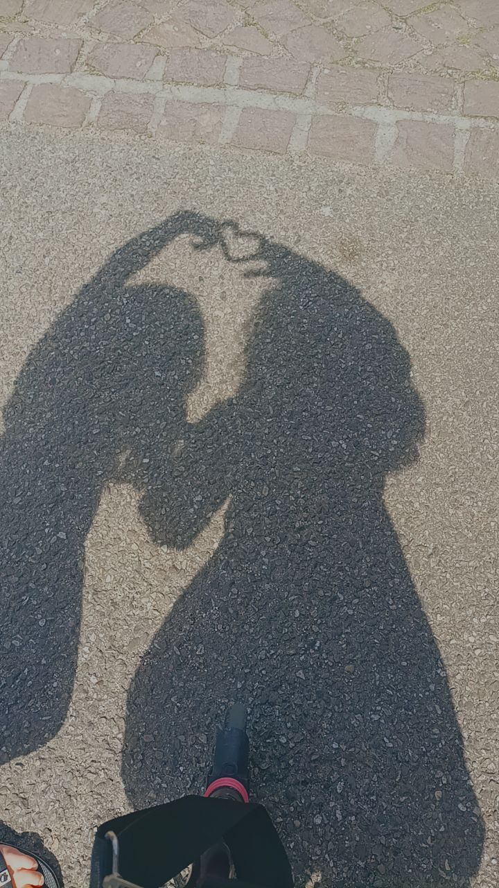 the shadow of a person standing next to a backpack