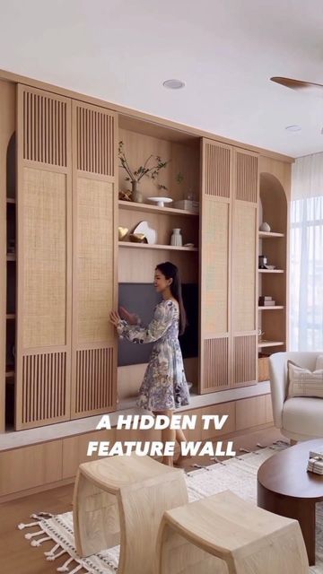 a woman standing in front of a tv next to a living room with furniture and decor