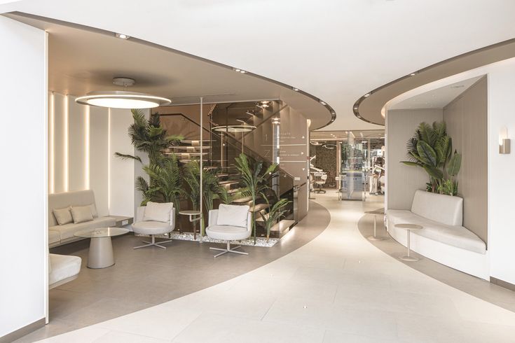 the interior of a modern office building with white furniture and plants in pots on the walls