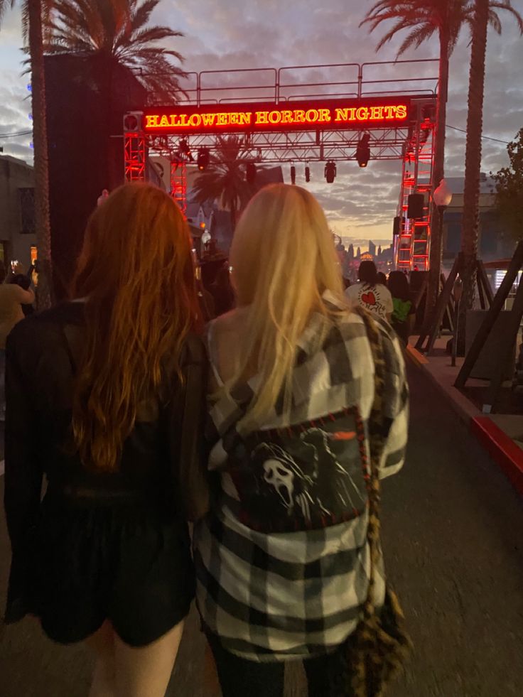 two women are walking down the street in front of a sign that says miami tomorrow