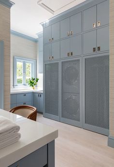 a kitchen with blue cabinets and white counter tops, along with a dining room table