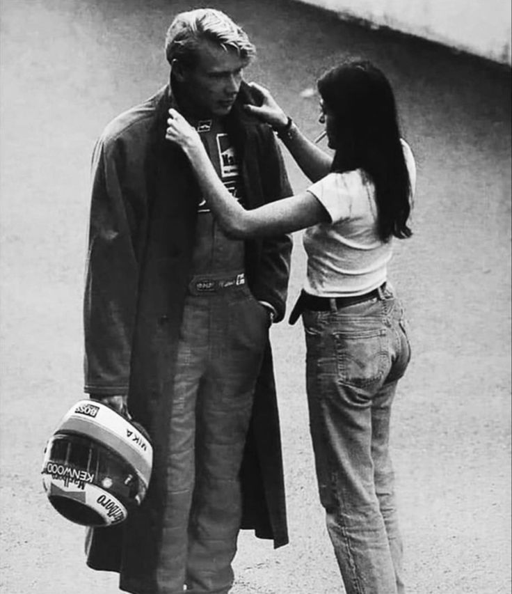 the man is fixing the woman's hat on her head while she stands next to him