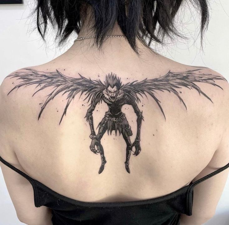 the back of a woman's shoulder with an image of a demon on it