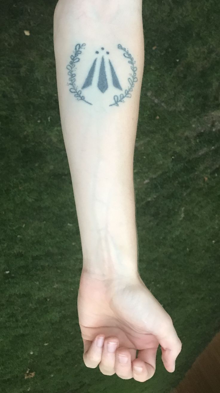 a person's arm with a tattoo on it that has two arrows in the middle