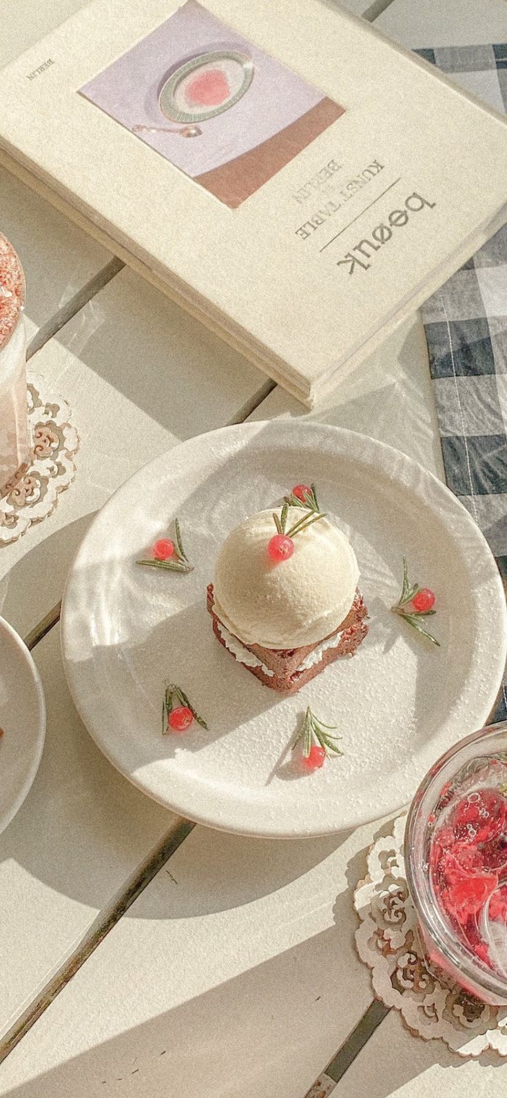 two desserts are sitting on plates next to an open book