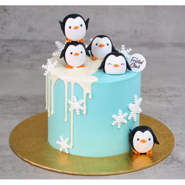 a cake decorated with penguins and snowflakes