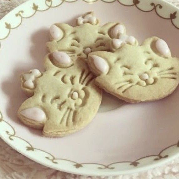 two cookies shaped like cats on a plate