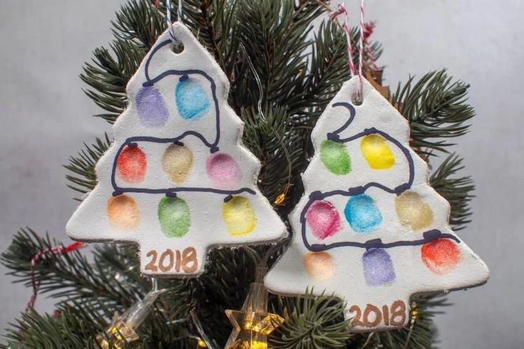 two christmas ornaments hanging from a tree with lights on it's sides and the year 2010 written on them