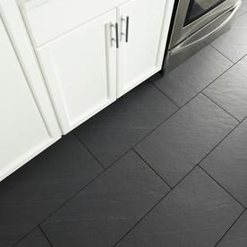 a kitchen with black tile flooring and white cabinets