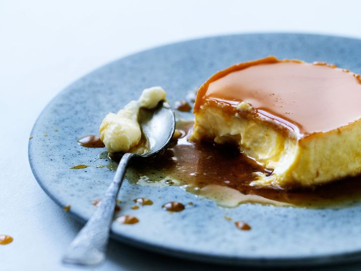 a piece of cake on a blue plate with a spoon and caramel drizzle