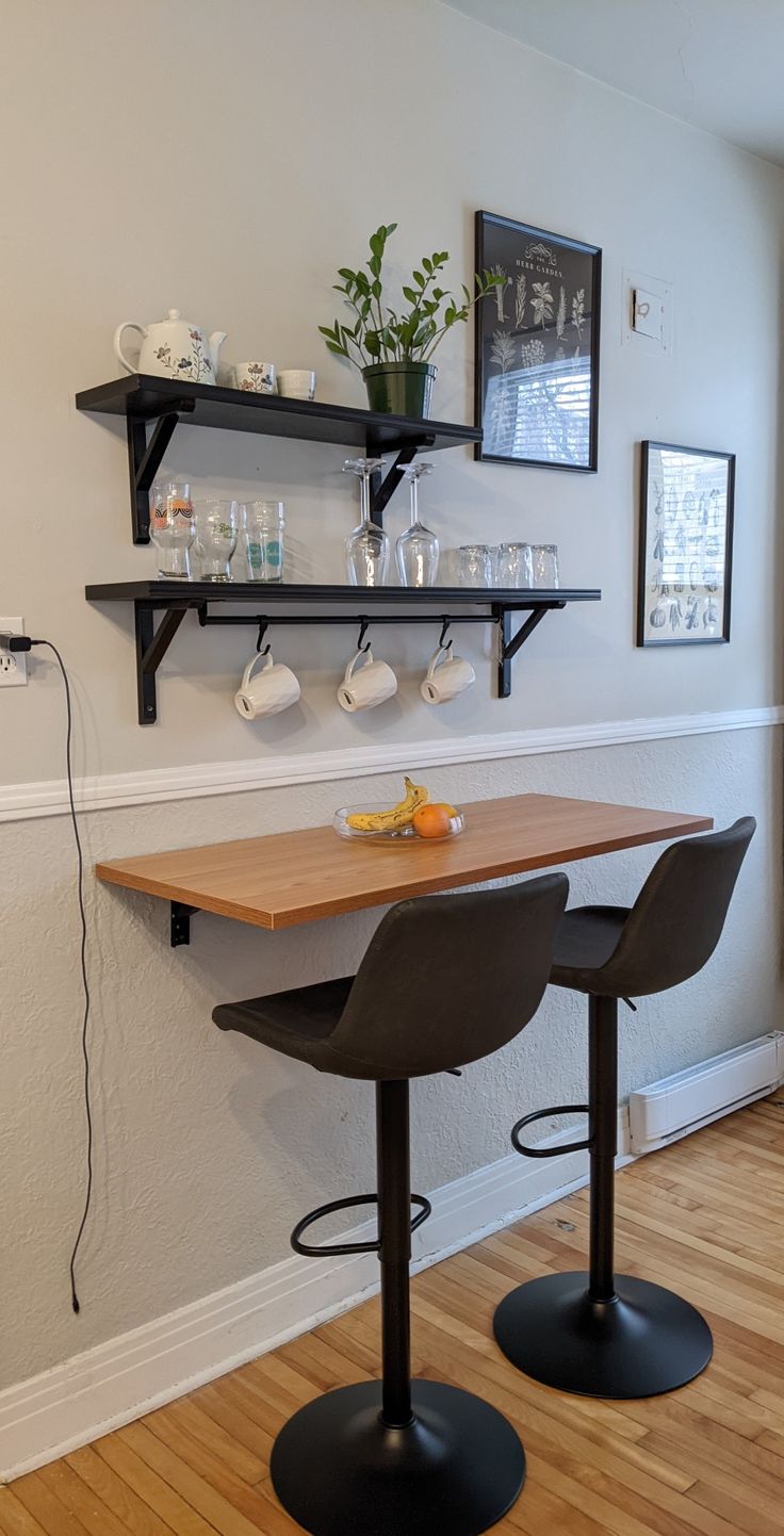 two bar stools sit in front of a table with cups and glasses on it