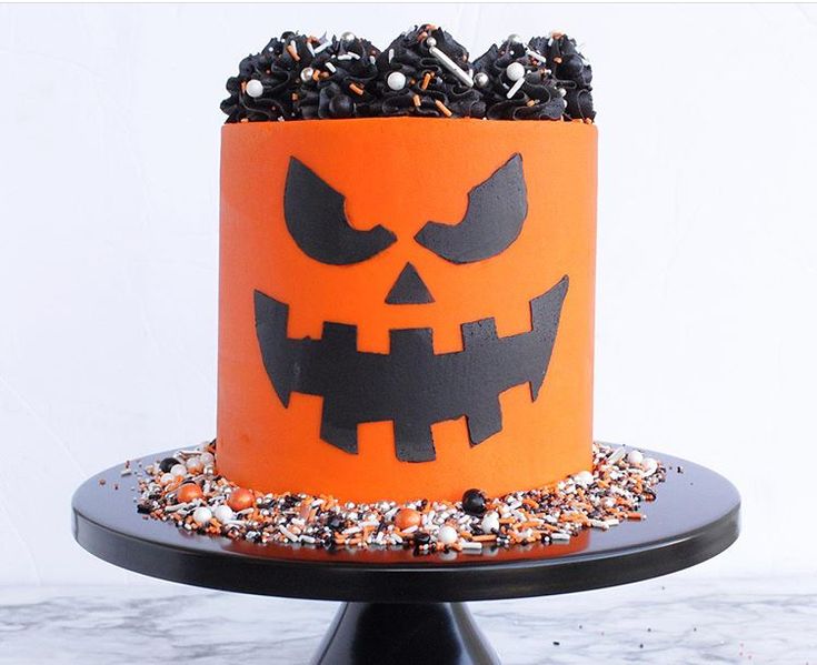 a halloween cake decorated with sprinkles and jack - o'- lanterns