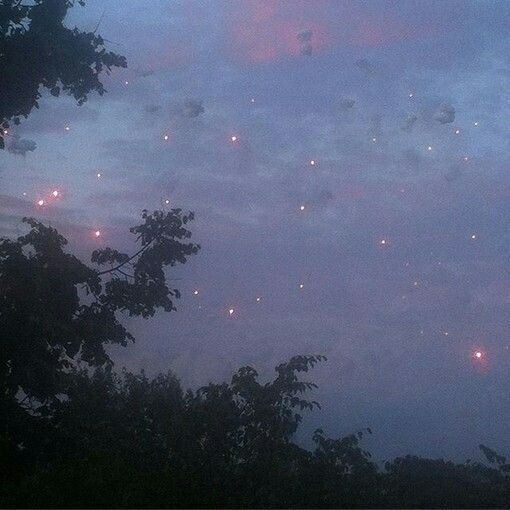 the sky is filled with fireflies as they fly through the clouds