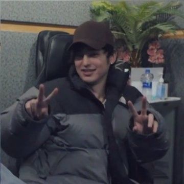 a man sitting in a chair making the peace sign