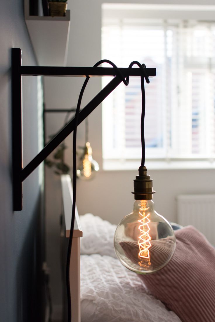 a light bulb hanging from the side of a bed