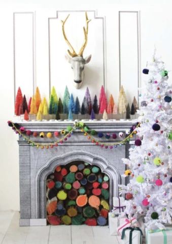 a decorated christmas tree in front of a fireplace with a deer head on the mantle