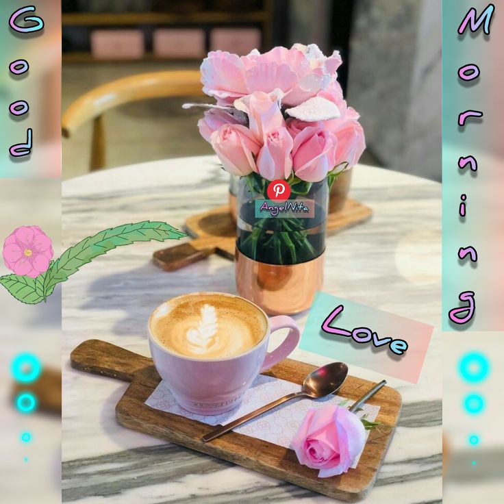 a cup of cappuccino on a table with pink roses in a vase