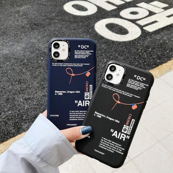 someone holding up their phone case in front of an air sign on the street,