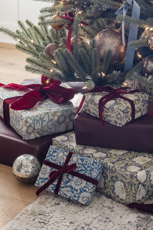 presents under the christmas tree are wrapped in red ribbon