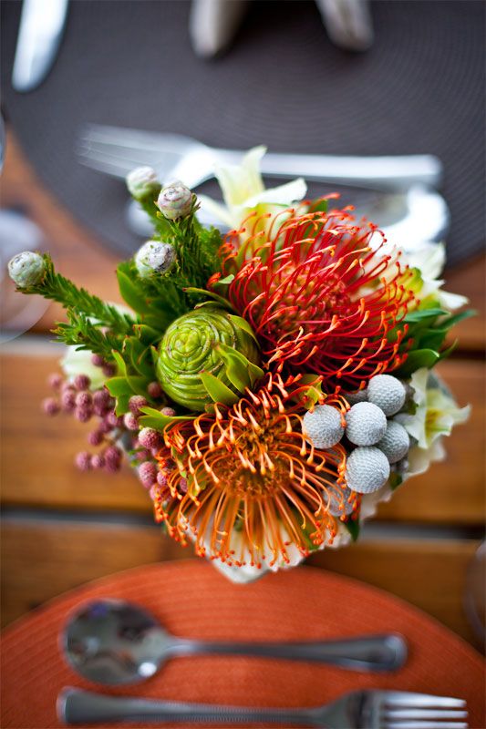 a vase filled with flowers sitting on top of a table next to a knife and fork