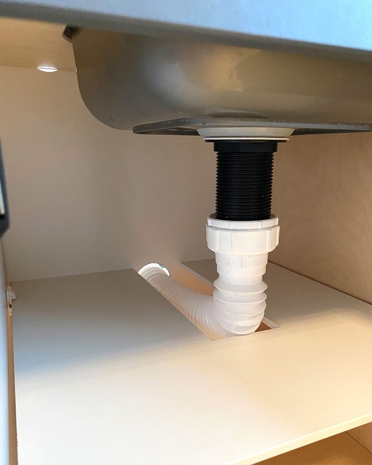 a white sink under a faucet in a bathroom next to a counter top