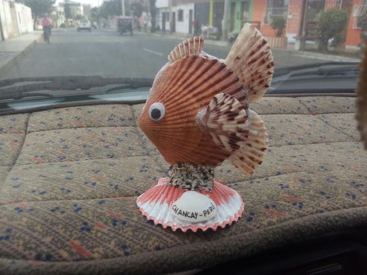 a toy fish sitting on the dashboard of a car