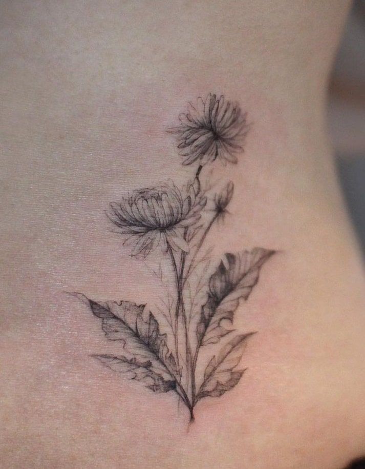 a woman's stomach with a flower tattoo on it