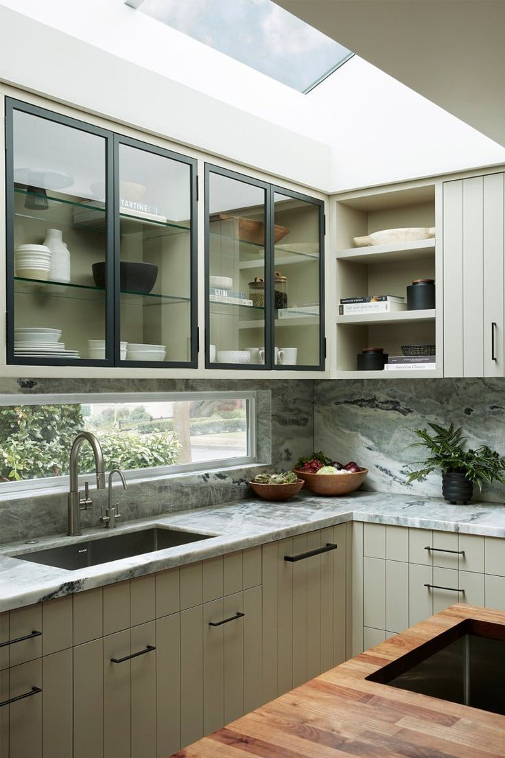 a kitchen filled with lots of counter top space and wooden counters under a skylight