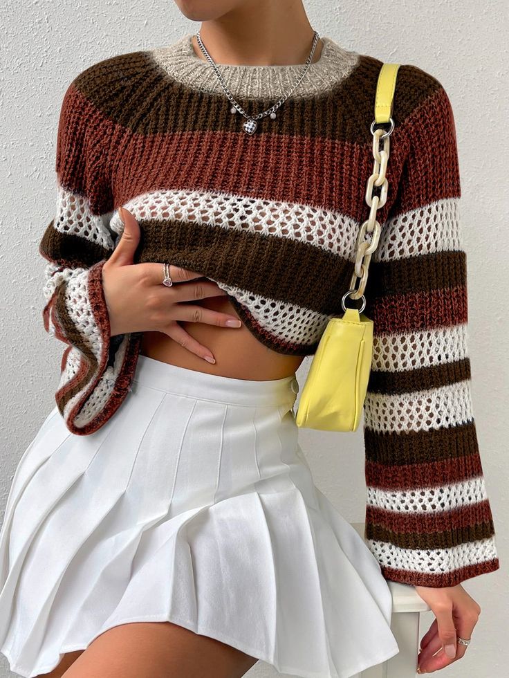 a woman wearing a brown and white striped sweater with a yellow handbag on her hip