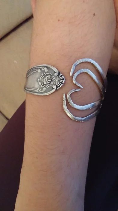 a close up of a person's arm with two rings on it and an open heart