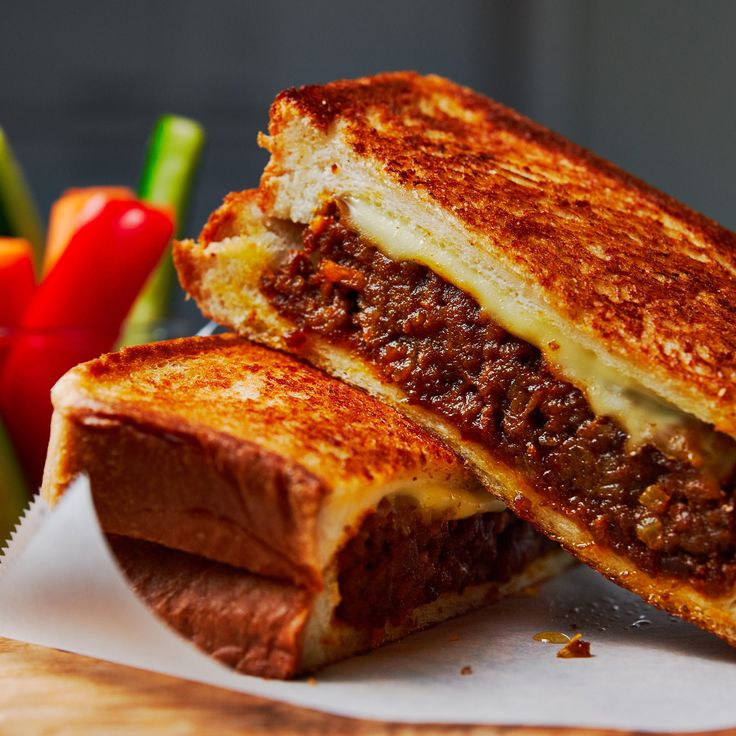 a sandwich cut in half sitting on top of a cutting board