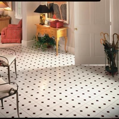 a living room filled with lots of furniture next to a white door and floor covered in tile