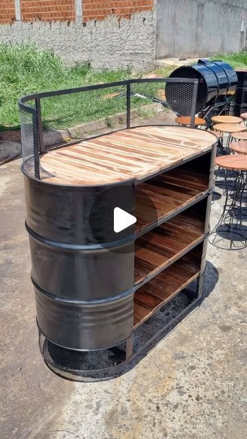 a large metal barrel sitting on top of a wooden table next to tables and chairs