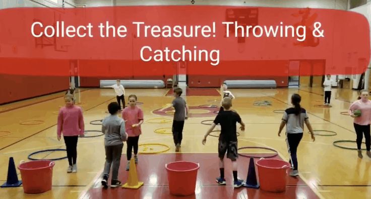 a group of people standing on top of a gym floor next to red buckets