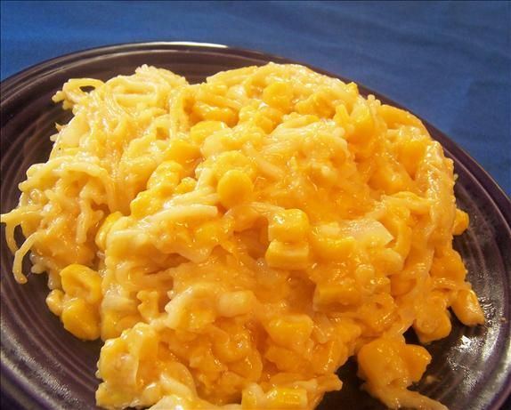 macaroni and cheese on a black plate with blue cloth in the back ground