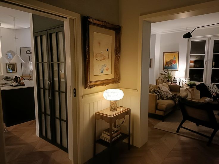 a living room filled with furniture and a painting hanging on the wall next to a doorway